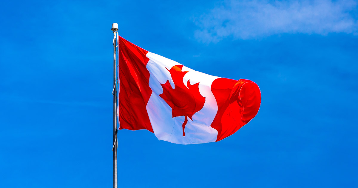 Canada flag waving against a blue sky